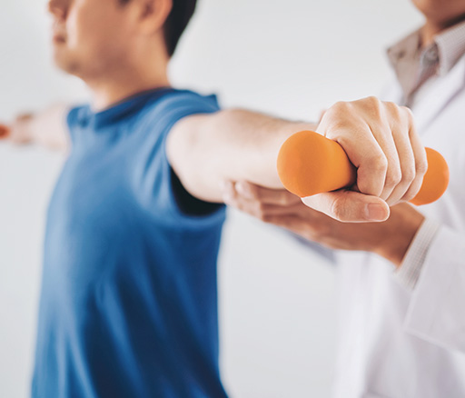 Chiropractor assisting patient with lifting hand weights